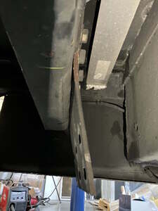 Bent rear bumper mounting plate before repair